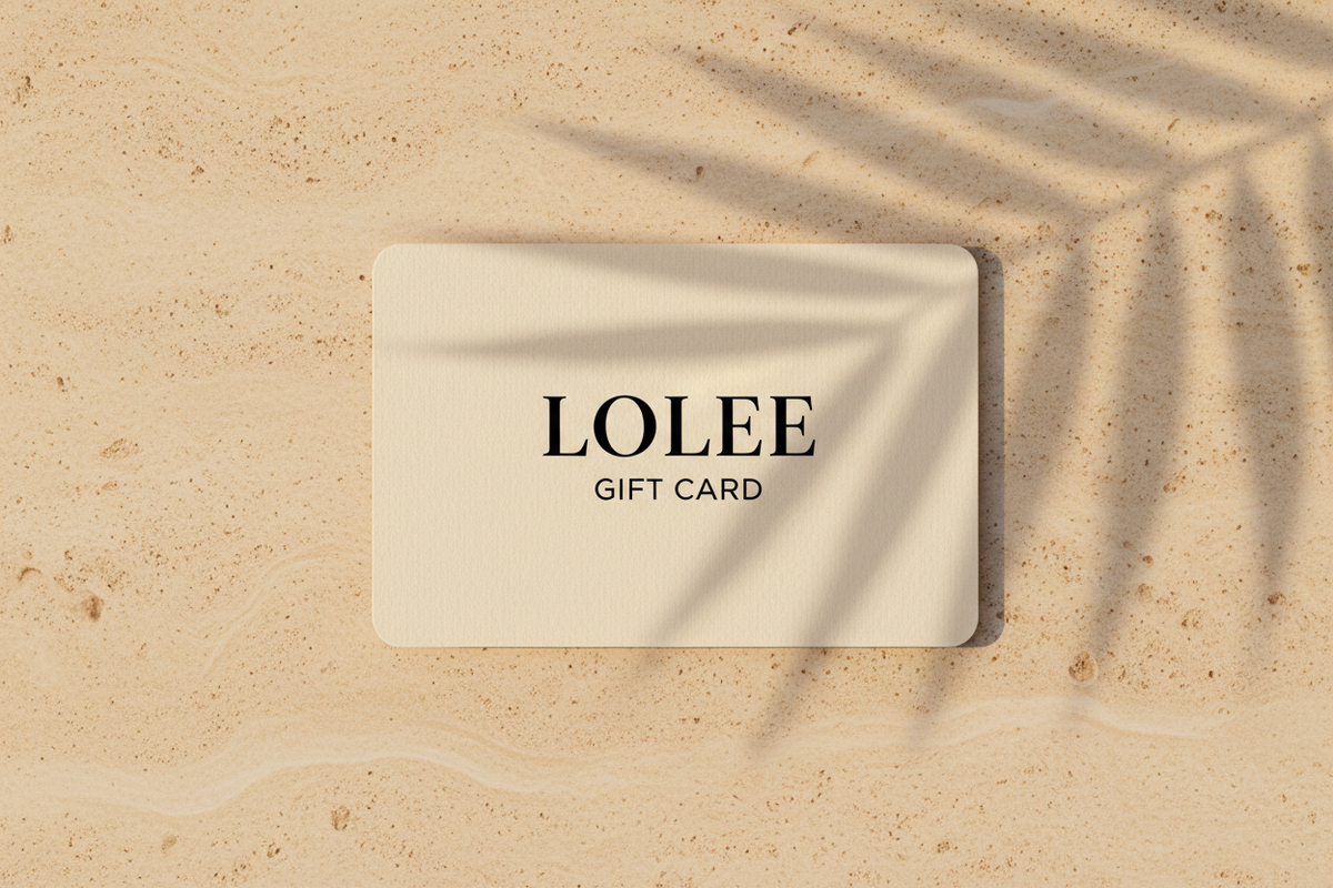 Ivory Lolee gift card on warm limestone with soft palm shadows