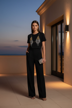 Black chain-drape tee styled on a Mediterranean terrace at dusk