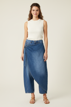 Front view of model wearing medium-blue Porto Wrap Barrel Jean with asymmetric denim overlay